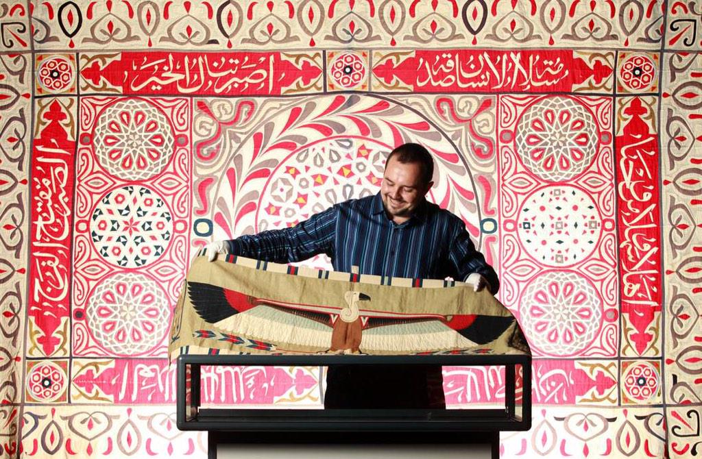 Dr Sam Bowker with the Syme Panels in the Khayamiya exhibition of the Albury LibraryMuseum February 2015 photograph by Kylie Esler